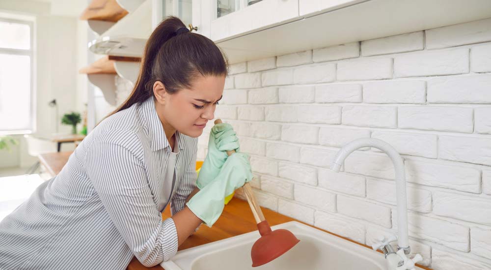 a frustrated person dealing with a clogged drain